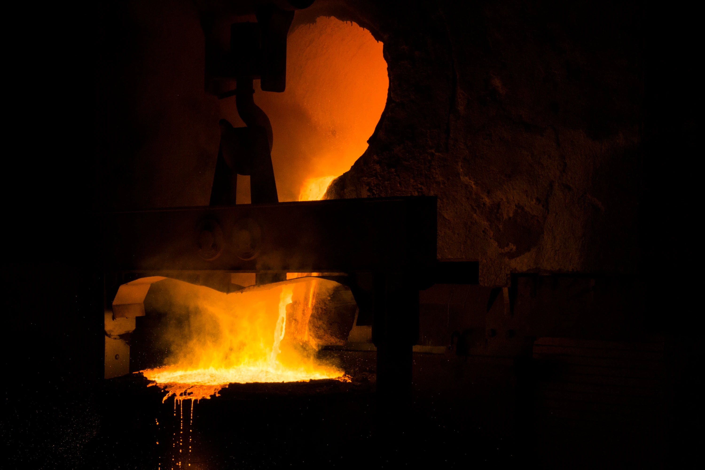 Molten metal glowing orange inside an industrial furnace