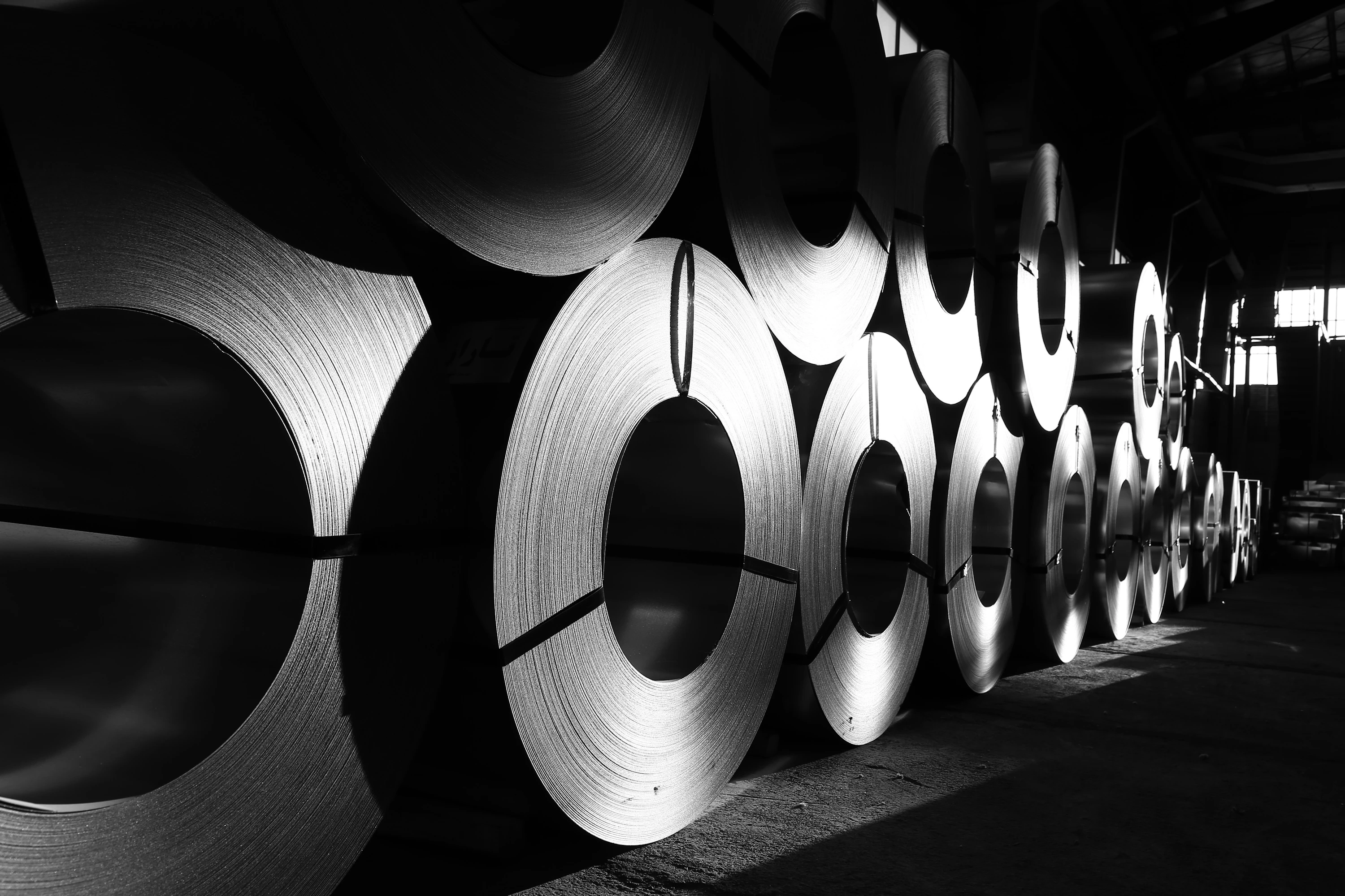 Rolls of new steel lined up in a warehouse